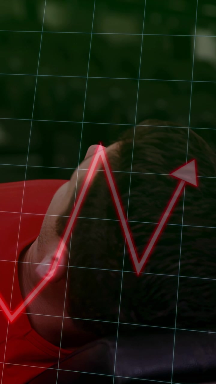 Vertical video: Man lying on side, grid overlay, red zigzag appearing later, indicating heart rate