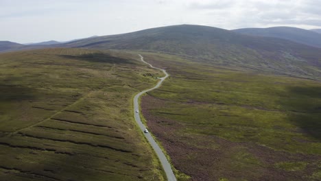 Luftaufnahme-Von-Autos,-Die-An-Einem-Sonnigen-Tag-Auf-Einer-Langen,-Kurvenreichen-Bergstraße-In-Den-Wicklow-Mountains-Fahren-6