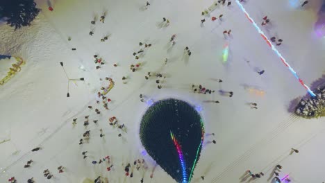 la cámara se eleva sobre el árbol de navidad y la multitud caminando en la plaza.