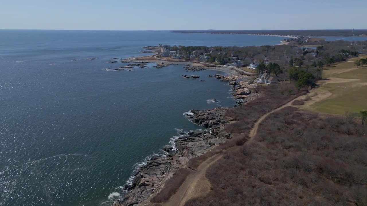 Il drone avanza, una vista aerea ampia e mozzafiato della costa del New Hampshire, con l'oceano vasto che si estende all'orizzonte.
