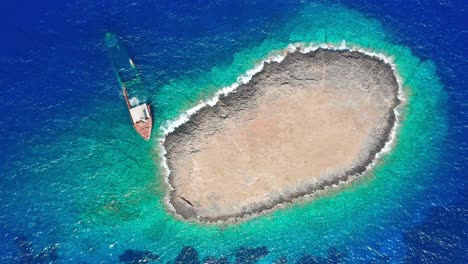 bird's eye view of a shipwreck beached with rocky island background