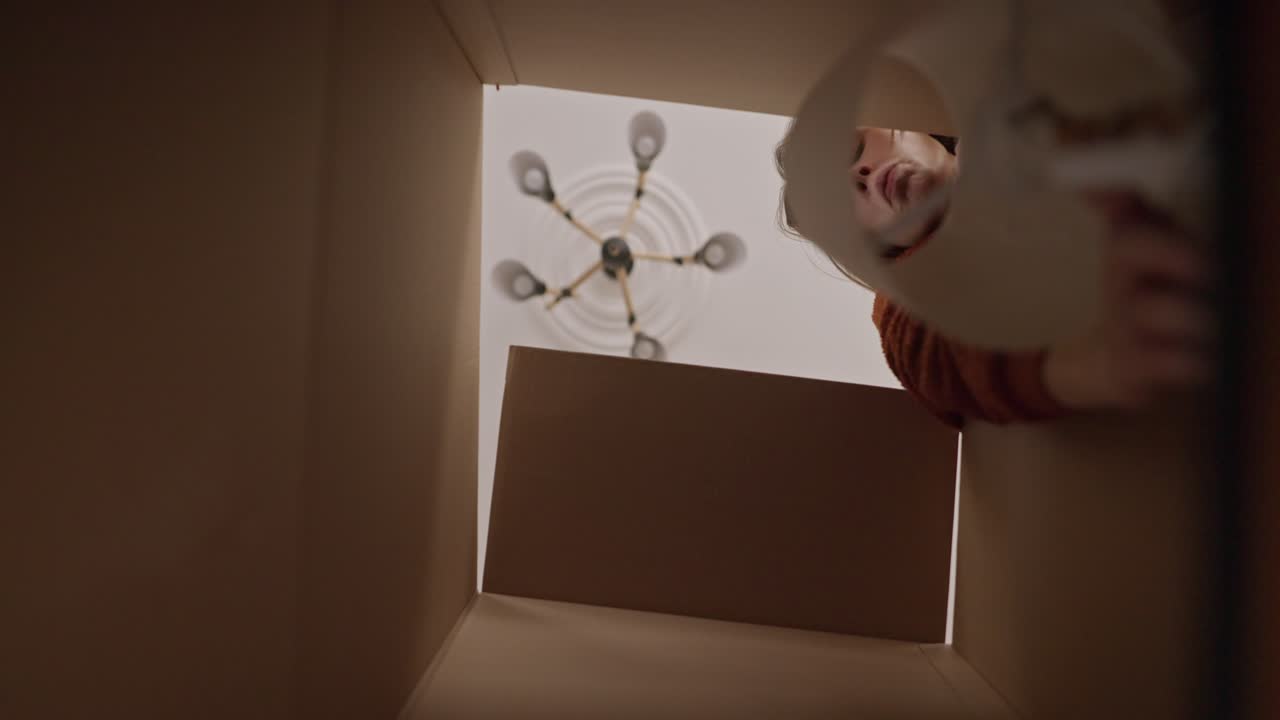 카드보드 상자 안을 바라보는 여자