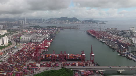 establishing shot of container port with urban skyline in the backdrop