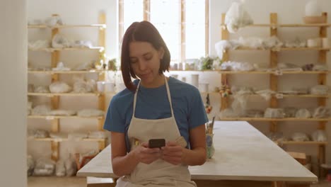 Young-female-potter-working-in-her-studio