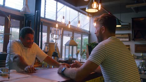 camarero hablando con un cliente masculino en el mostrador 4k