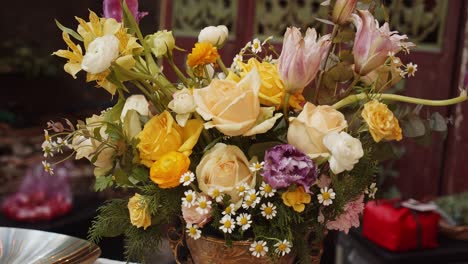 a bucket of colorful flowers standing on outdoor catering table