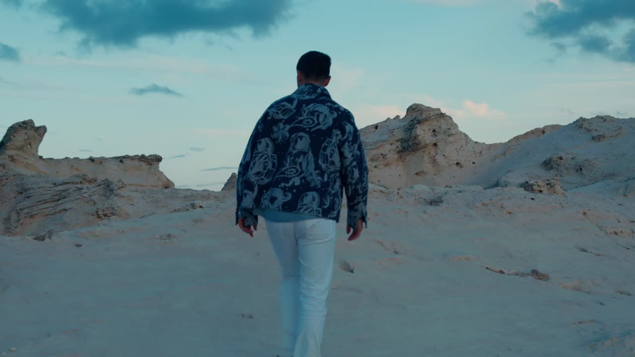 turista caminando solo por las dunas de arena en la laguna de la playa de cleopatra en marsa matrouh, egipto