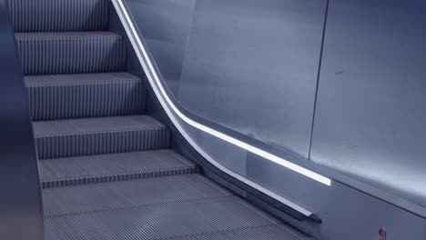 Nobody-using-silver-up-escalator-at-clean,-modern-city-transit-station