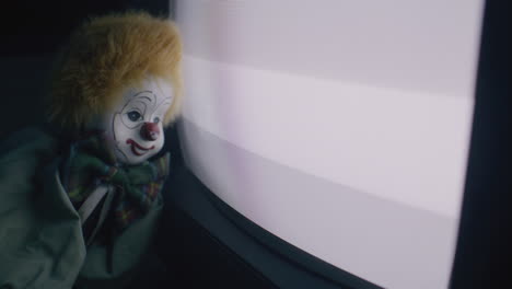 creepy clown beside old tv