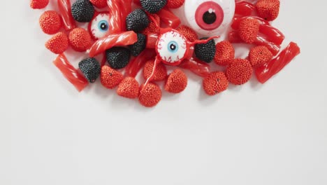 vista de cerca de la variedad de dulces de halloween caídos contra un fondo gris