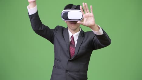 joven empresario asiático usando auriculares de realidad virtual