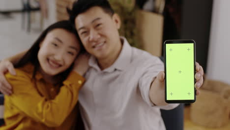 couple holding a smartphone with green screen