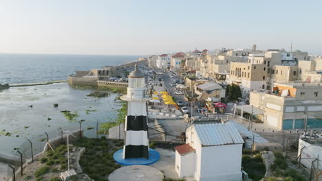 Luftaufnahmen,-Die-Im-Licht-Des-Sonnenuntergangs-Um-Den-Leuchtturm-Von-Acre,-Israel,-Rotieren