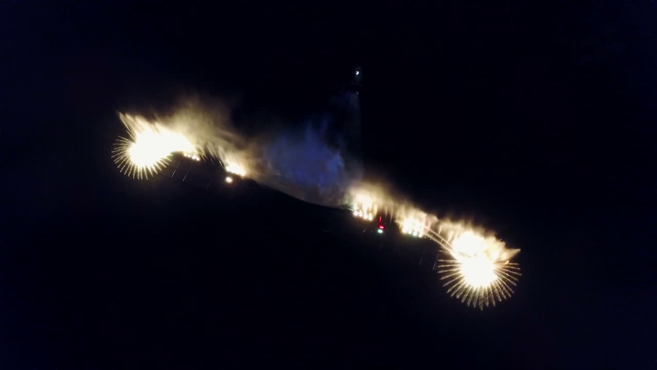 Water Music Fountain In Night. Aerial shot of the dancing colorful fountain with reflection on water at night