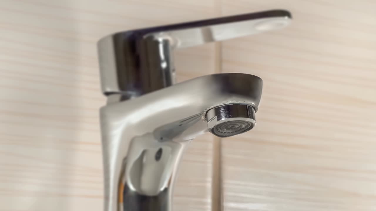 Acqua che gocciola da un rubinetto - perdita d'acqua, valvola non chiusa.