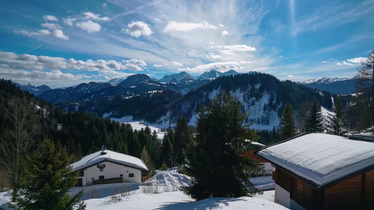 cinemagraph aerial seamless video loop time lapse de un pintoresco e idílico valle de montaña en invierno con hielo, nieve y aire fresco en los alpes austriacos bávaros con una cordillera y picos y un bosque natural con árboles.