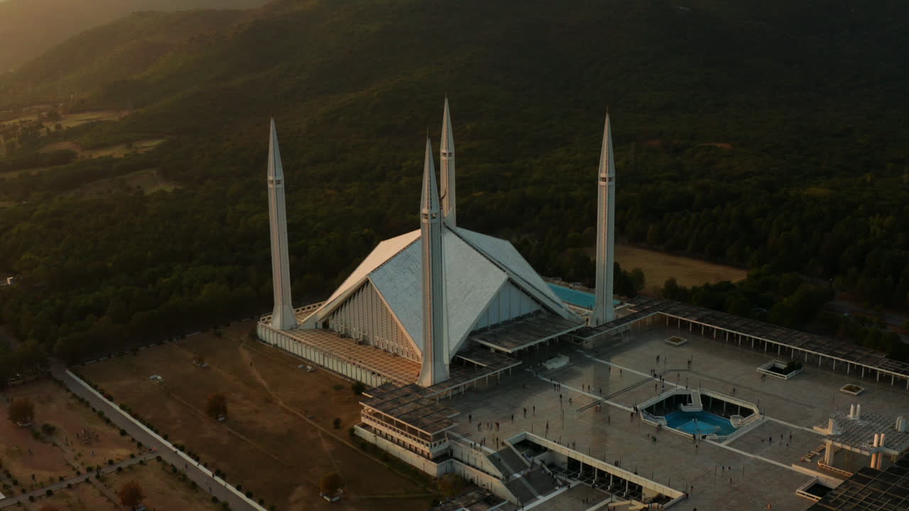 파키스탄 이슬라마바드에서 황혼에 파이살 모스크 안뜰을 걷는 사람들