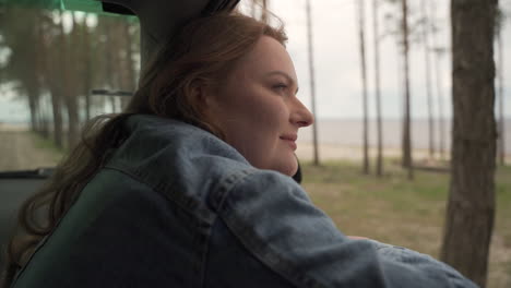 Red-Haired-Woman-Enjoys-A-Drive-Through-The-Countryside-Next-To-The-Lake