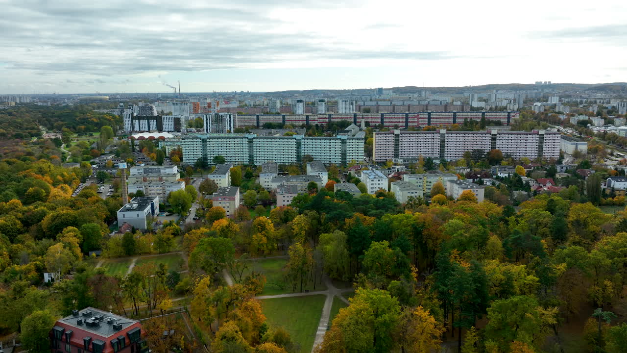 Drone panorama of Gdańsk Przymorze with large apartment blocks surrounded by colorful autumn trees