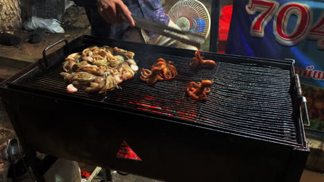 Dos-Cocineros-Asando-Calamares-Por-La-Noche,-De-Cerca