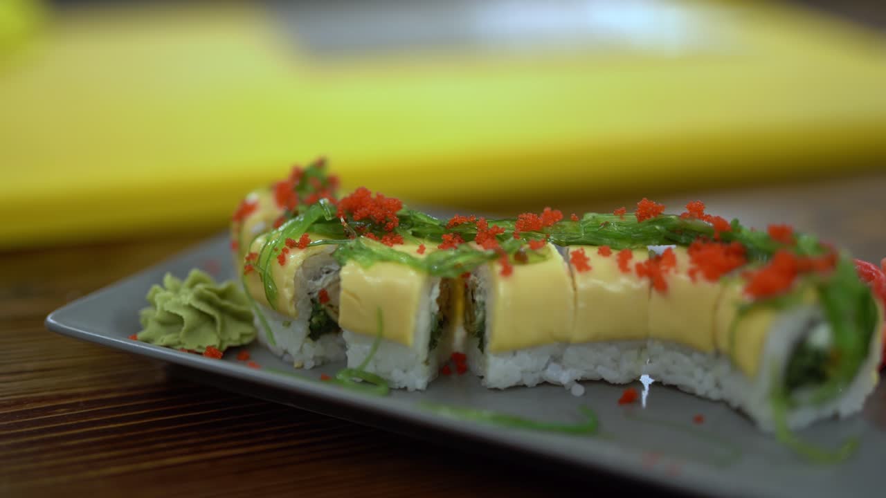 un video de primer plano de un rollo de sushi extremadamente hermoso y sabroso con algas y caviar en él
