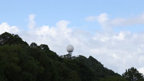 cúpula de radar en la colina con patrones de nubes cambiantes