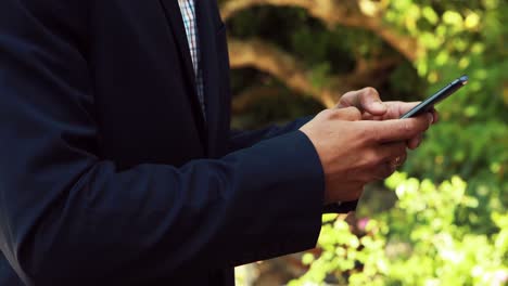 businessman using mobile phone in park 4k