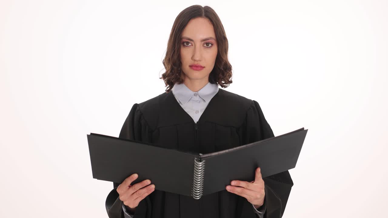 Female judge in black robe holding a book