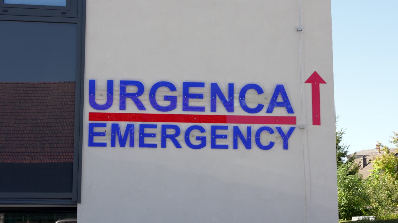 Emergency department sign on hospital wall with direction arrow showing way to urgent medical care entrance