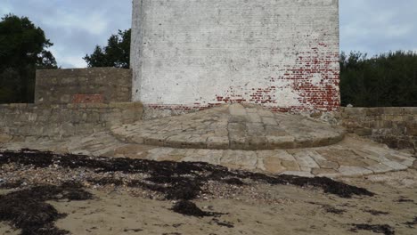 Old-St-Helens-tower-in-the-coat-of-the-Isle-of-Wight-,-camera-moving-upwards-from-the-beach-to-the-top-of-the-tower