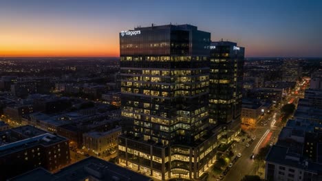 aerial view of a modern urban corporate building at dusk, showcasing architectural design and cityscape along with vibrant sunset colors