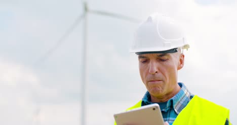 Ingeniero-Que-Usa-Tableta-Digital-Al-Hacer-La-Inspección-De-Aerogeneradores-9