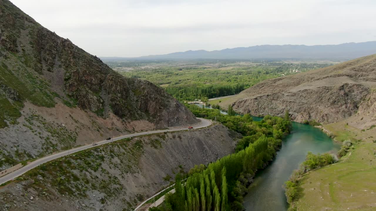 vista aérea del río de montaña con la presa y la carretera con la tarjeta pasando por