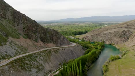 aerial view of mountain river with the dam and road with card passing by