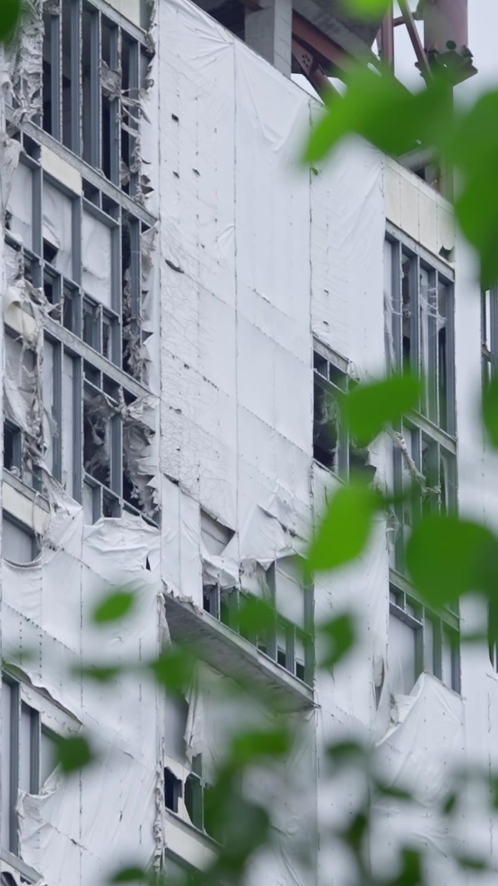 Edifício Alto Inacabado com Lona Protetora Branca Rasgada