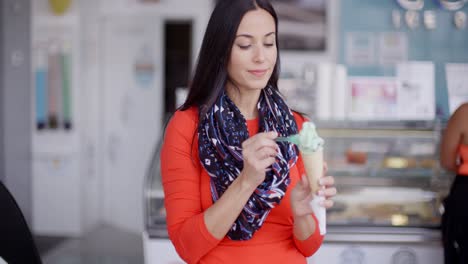 Smiling-young-woman-savoring-an-ice-cream-cone