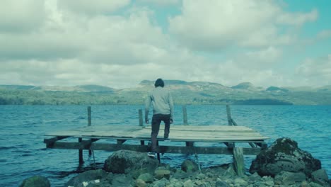 Young-man-walks-onto-pier-to-enjoy-the-scenic-view