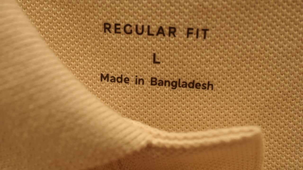 옷의 라벨에'regular fit', 'l','made in bangladesh'라는 글자가 새겨져 있습니다.