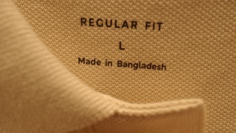 close up of a clothing label that reads "regular fit", "l", and "made in bangladesh".