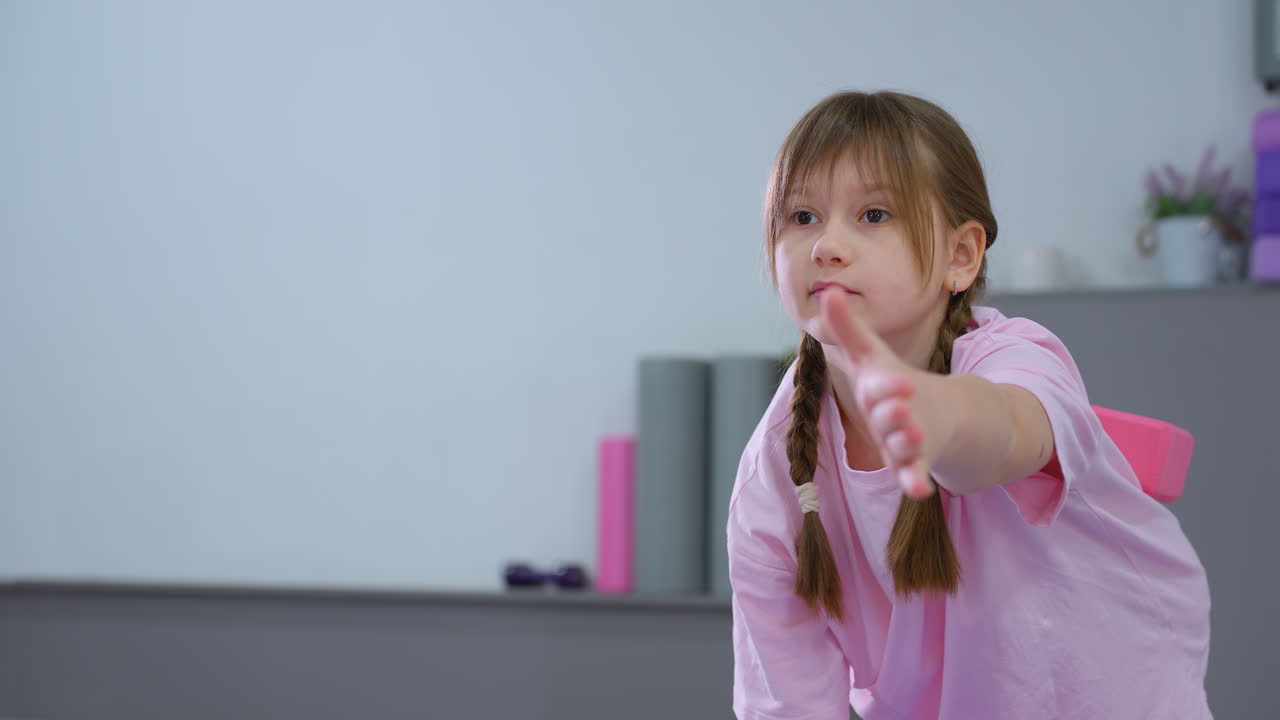 뒷면의 분홍색 블록에 초점을 맞추고 운동 중에 안정성과 자세를 향상시키는 리 리로 앞으로 어있는 어린 아이의 근접