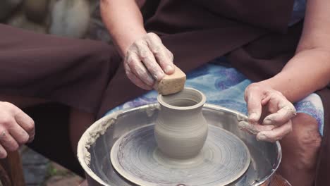 grandmother with a grandchildren make pitchers in pottery