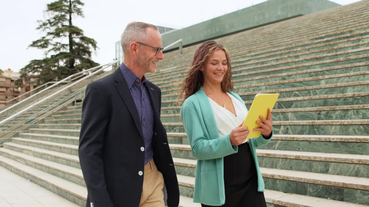 Business people using a tablet on city stairs