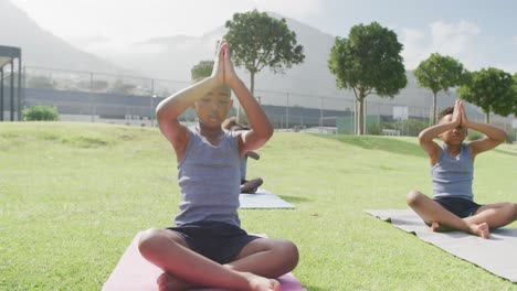 video de tres escolares afroamericanos practicando meditación en una clase al aire libre