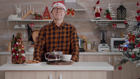 Retrato-De-Un-Hombre-Mayor-Con-Sombrero-De-Papá-Noel-Sonriendo-Mientras-Mira-A-La-Cámara-Durante-La-Mañana-De-Navidad