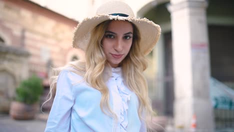 attractive young beautiful girl with hat walks and discovers places in narrow street