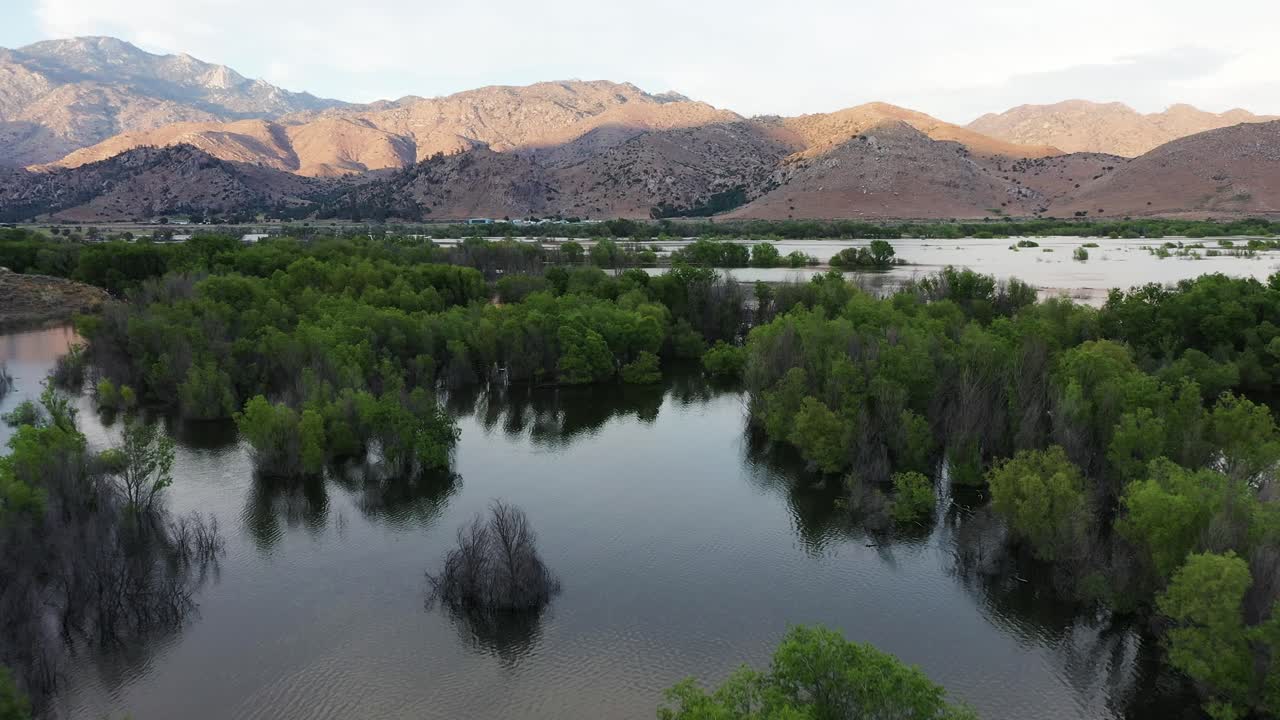 lago isabella kernville california después de una inundación al atardecer con luz dorada golpeando la montaña fondo dolly aérea hacia adelante
