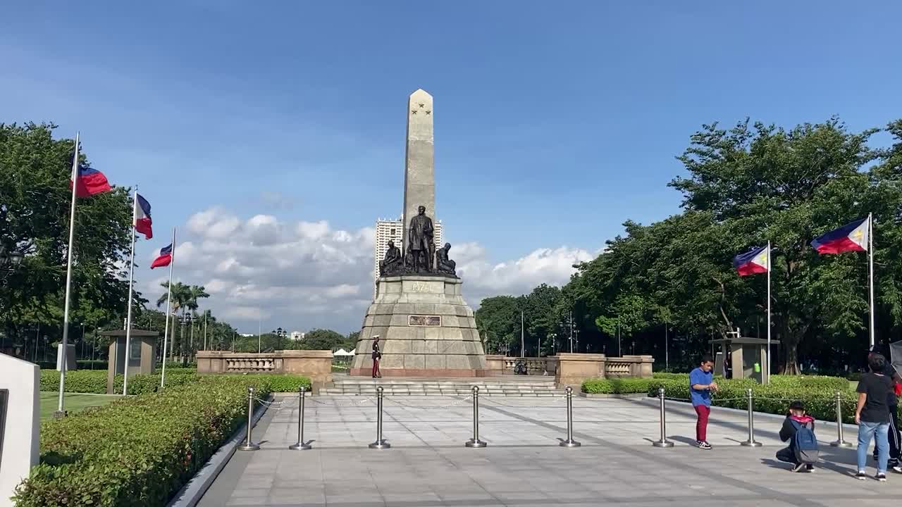 Tourists take pictures in front of monument honoring Filipino nationalist Jose Rizal
