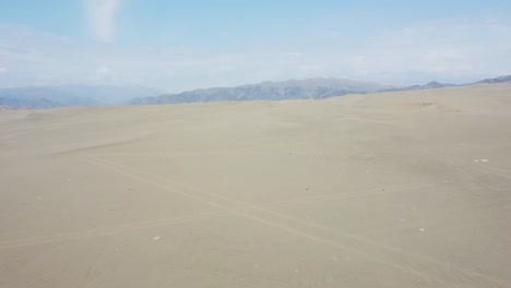 el dron vuela hacia adelante sobre las dunas de arena en el desierto