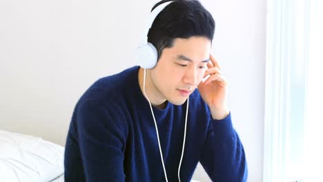 침실 4k에서 디지털 태블릿에서 음악을 듣는 남자
