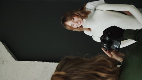 female model posing with mannequin against dark background in photo studio